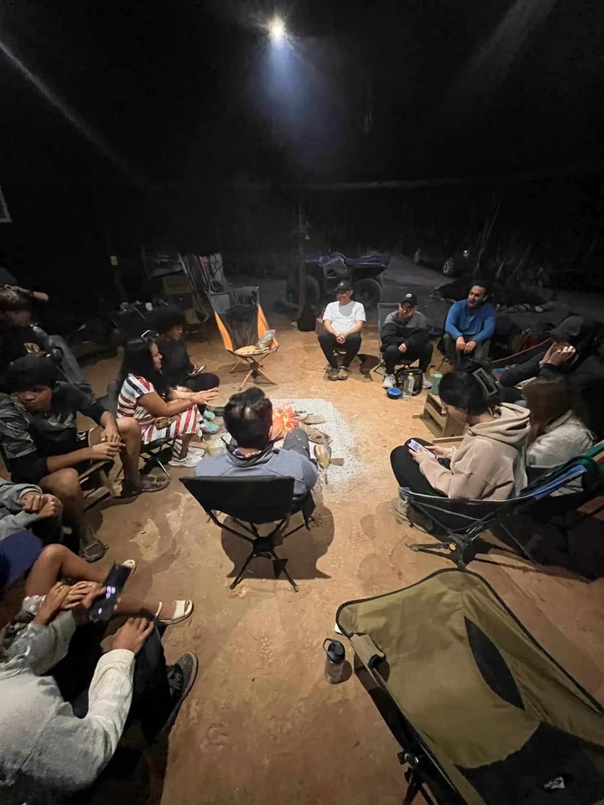 Guests gathered in a circle around the fire at night in Yaogará
